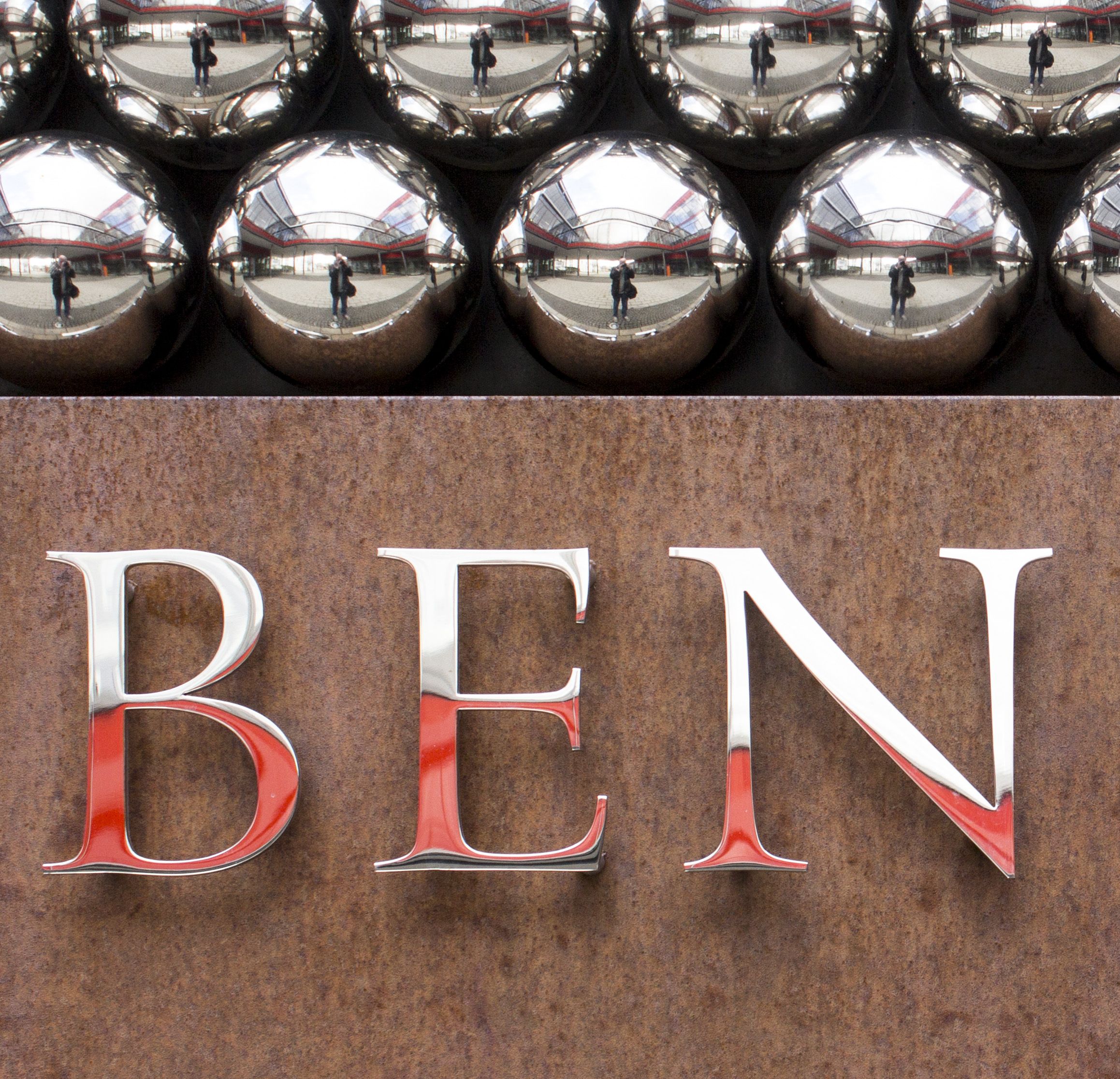 Detailed view of the capital letters B, E, N in stainless steel